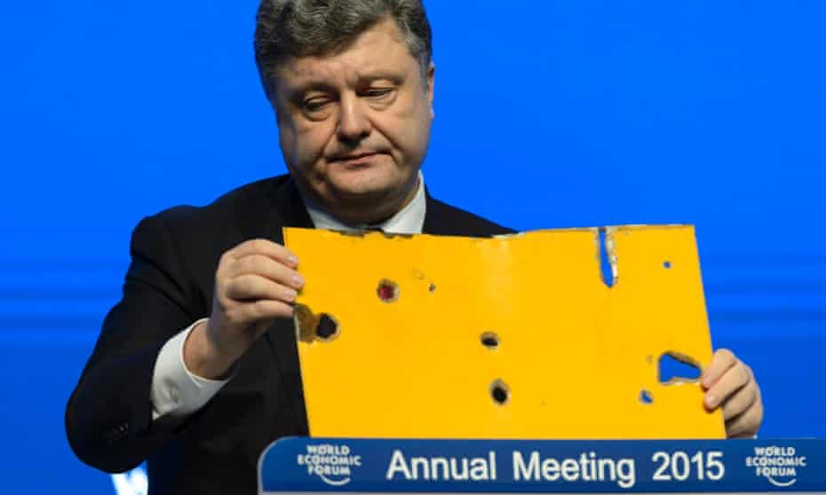 The president of Ukraine Petro Poroshenko speaks with a piece of a damaged passenger bus hit by a shell that killed twelve passengers and injured 13 others at a Ukrainian military checkpoint near the town of Volnovakha, during a panel session today.