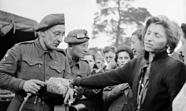 A British soldier sprays DDT (to combat insect-born typhus) on a recently liberated female prisoner from the Bergen-Belsen concentration camp