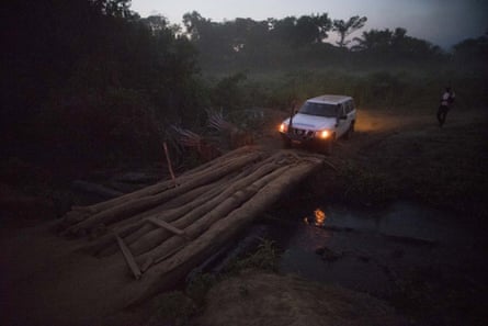 Aid workers cross a bridge in DRC's Equateur Province