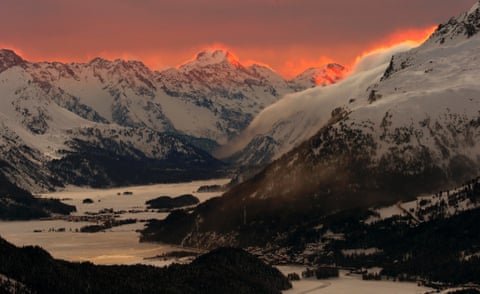 The setting sun illuminates the peaks of the mountains near the Swiss mountain resort of St Moritz.