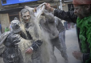 A man is lost in billowing cloud of flour, as others gang up on him during the melee.