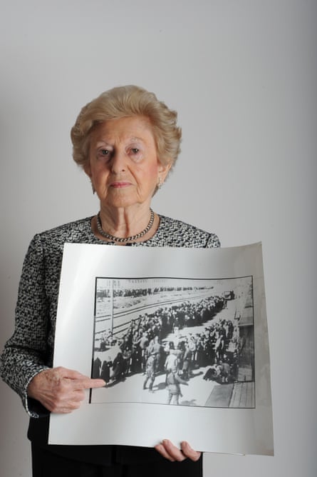 Irene Fogel Weiss holds a photo of her that was taken at Auschwitz by two Nazi guards.