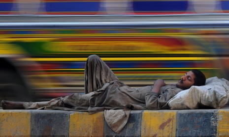 A Pakistani homeless man rests by a road in Karachi.