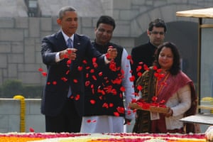President Obama throws rose petals as he pays his respects at Raj Ghat, the memorial for Mahatma Gandhi, in New Delhi