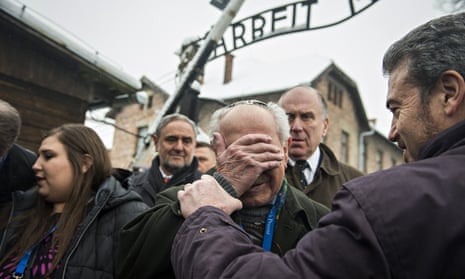Survivor Mordechai Ronen is comforted by his son as he arrives at Auschwitz on Monday.