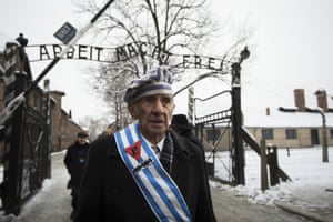 Auschwitz survivor Miroslaw Celka walks out the gate with the sign saying Work makes you free after paying tribute to fallen comrades at the death wall execution spot