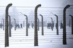 Visitors walk behind barbed-wire fences at the memorial site of the former Nazi concentration camp Auschwitz-Birkenau in Oświęcim, Poland