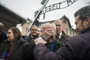 Holocaust survivor Mordechai Ronen, centre, is comforted by his son as he is overcome by emotion