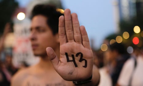 A demonstrator in Mexico holds up his hand with the number 43, in reference to the missing students. The Mexican attorney general has concluded that all of the group were murdered.