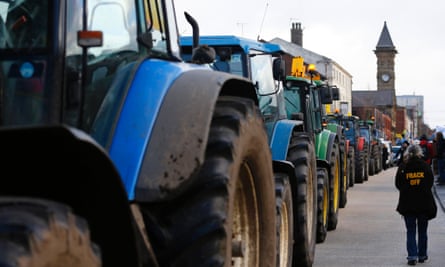 A woman walks down a line of tractors during an anti-fracking protest in Preston, northern England January 28, 2015. A local English government council has voted to delay a decision on whether shale gas firm Cuadrilla can progress with two fracking projects, in a case that is being closely watched by the industry and environmental campaigners.