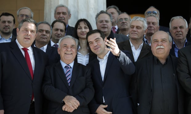 Alexis Tsipras, accompanied by members of his government, poses for a group picture outside the parliament in central Athens.