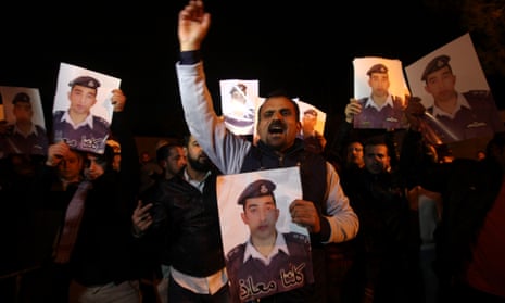 Jordanians demonstrators hold portraits of the  pilot Muath al-Kasabeh, held hostage by Isis, in front of the royal palace in Amman, Jordan.