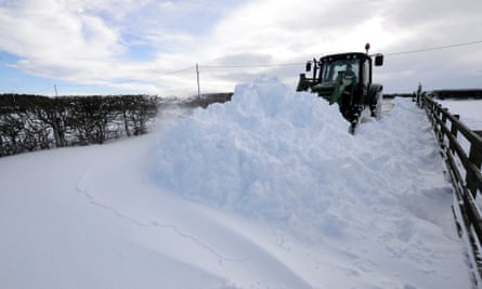 A farmer uses a tractor to clear a road of snow in Oakenshaw, County Durham.