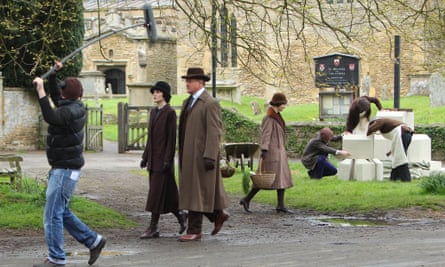 The cast of Downton Abbey film scenes on location outside a churchyard.