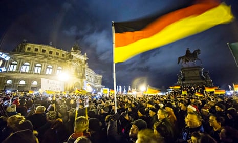 Participants hold German national flags during a demonstration by anti-immigration group Pegida outs