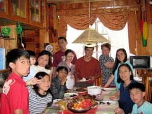 a filipino family gathered around a table with food