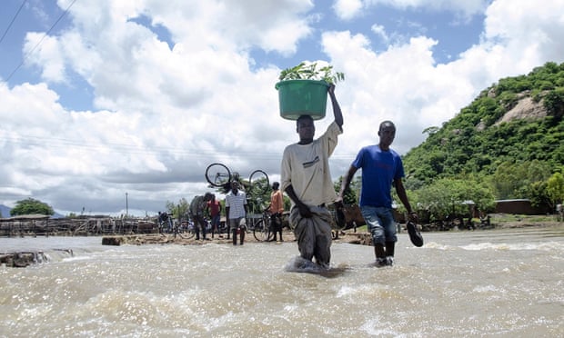 People cross a river with their belongings where a bridge once stood in Phaloni, Southern Malawi,  January 22, 2015. Malawi has been affected by flooding caused by heavy rains, with scores of people having died and some 200,000 displaced.
