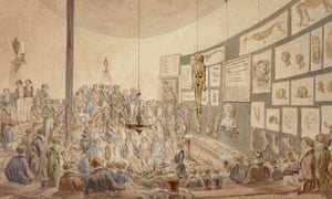 A lecture at the Hunterian Anatomy School, Great Windmill Street, London c. 1830. Male students in frock coats sit around an amphitheatre-like room watching a dissection. A skeleton hangs from the ceiling, and the back wall is covered in pictures of dissections.