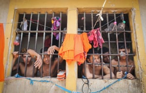 Inmates look through the bars of their cell