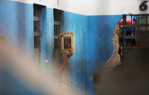 An inmate uses a mirror to see visitors