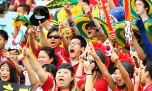 A few excitable South Korea supporters cheer as they wait for the start of the match.