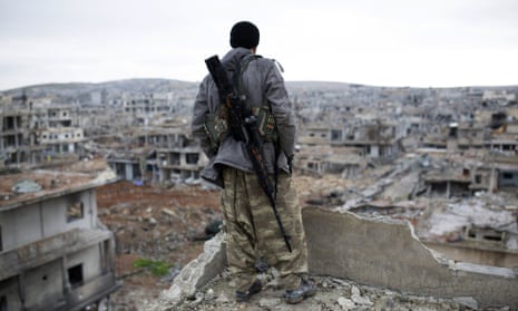 A Syrian Kurdish sniper looks at the rubble of Kobani, which Islamic State controlled half of before being driven from the town.