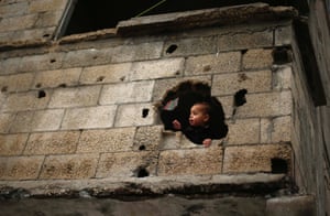 Gaza City, Gaza  A Palestinian boy looks out through a hole in his family home