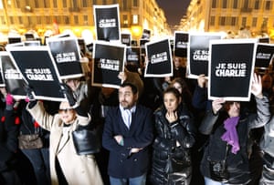 People hold up placards reading at a gathering in Nice