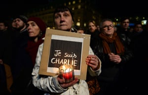 A stands at a vigil in front of the French embassy in Berlin