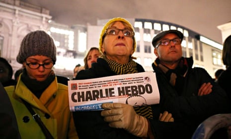 A woman holds a copy of Charlie Hebdo