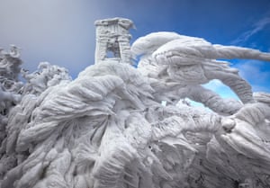 Heavy frost and large ice spike formations envelop a watchtower and trees at Mount Javornik on December 9, 2014 in Javornik, Slovenia.  THESE incredible ice formations were created when freezing fog descended on a mountain range. The images were captured by photographer Marko Korosec who travelled to the top of Mount Javornik in Eastern Slovenia and noticed that hard rime had been accumulating in the mountains. Hard rime is a white ice that forms when the water droplets in fog freeze onto a surface.