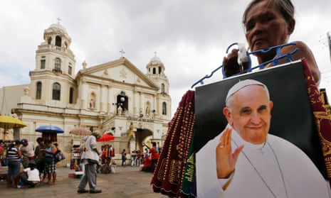 A Filipino vendor sells Pope Francis souvenirs in front of a church in Manila, Philippines