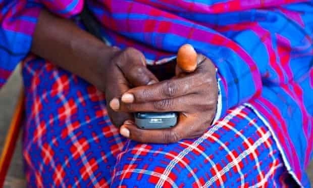 Maasai tribesman using a mobile phone in the Masai Mara, Kenya