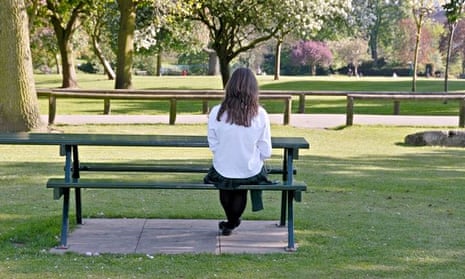 Girl sitting alone on park bench