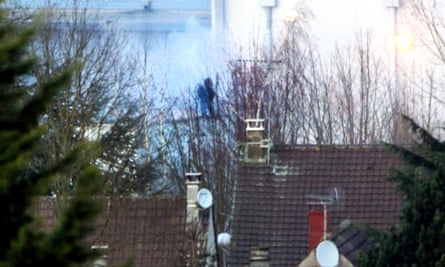 Smoke rises as special forces enter the building where the suspects were holding a hostage