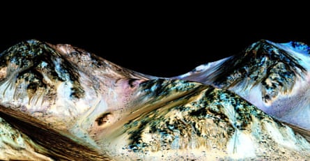 A handout image made available by NASA on September 27, 2015, shows dark, narrow, 100 meter-long streaks called recurring slope lineae flowing downhill on Mars, inferred to have been formed by contemporary flowing water.