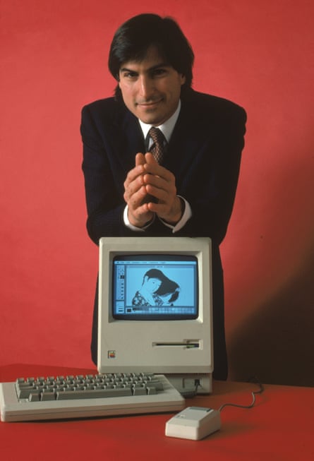 Jobs leans with the Macintosh 128K, the original Macintosh personal computer, 1984.