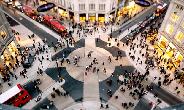 A high-angle view of shoppers walking across the X-shaped pedestrian crossing at Oxford Street in London