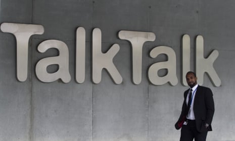 Man walks past Talk Talk sign