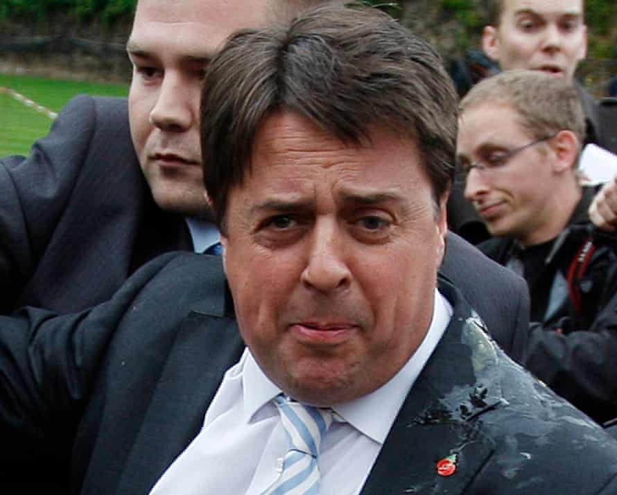 Former BNP leader Nick Griffin leaves a 2009 news conference with egg on his jacket after it was disrupted by protesters.
