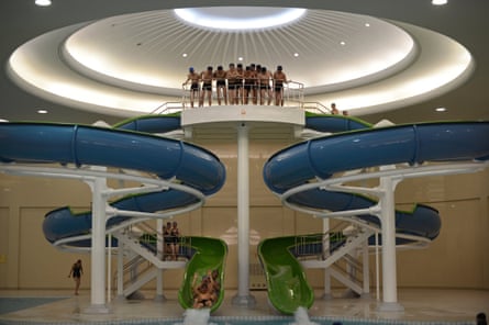 North Korean students ride down a water slide into a swimming pool at Kim Il-Sung University in Pyongyang on 11 April, 2012.
