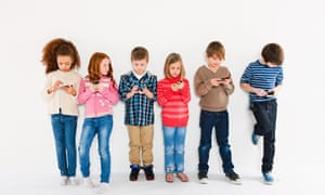 Children using smartphones, standing in a row