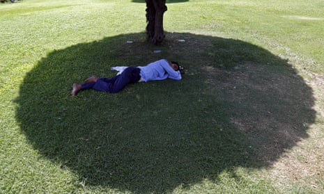 A man sleeps under the shade of a tree during a May 2015 heat wave in New Delhi, India.