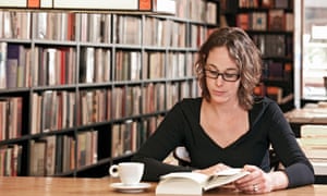 A woman reading in a bookstore.