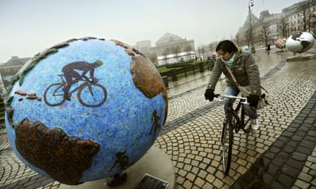 A cyclist stopping to look at a display, entitled "Cool Globes, an exhibition about combating global warming and climate change, in the Kongens Nytorv area in the centre of Copenhagen.