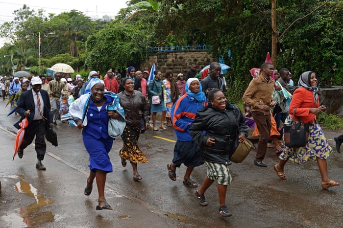 Crowds run to queue in the rain as they wait to enter a mass by Pope Francis in Nairobi.