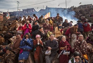 Tibetan Buddhists pray on a hillside during a morning chanting session