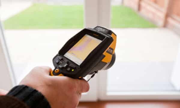An architect uses a thermal imaging camera to test the thermal efficiency of a house