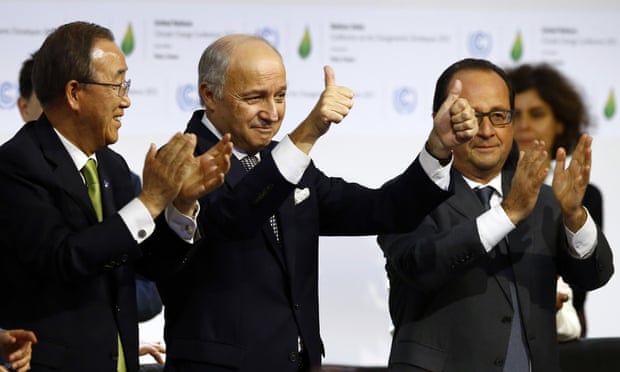 French foreign minister and President of the COP21 Laurent Fabius, center, applauds while United Nations Secretary General Ban Ki-moon, left, and French President Francois Hollande applaud after the final conference of the COP21.