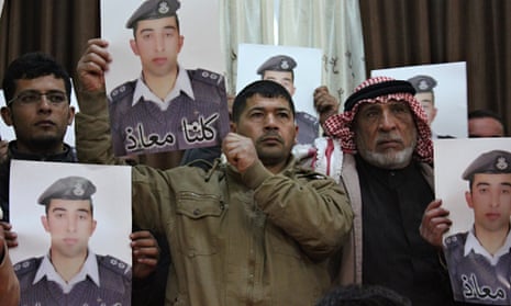 Relatives of Isis captive Muath al-Kasasbeh at a rally in Karak. The words on the portrait read 'We 